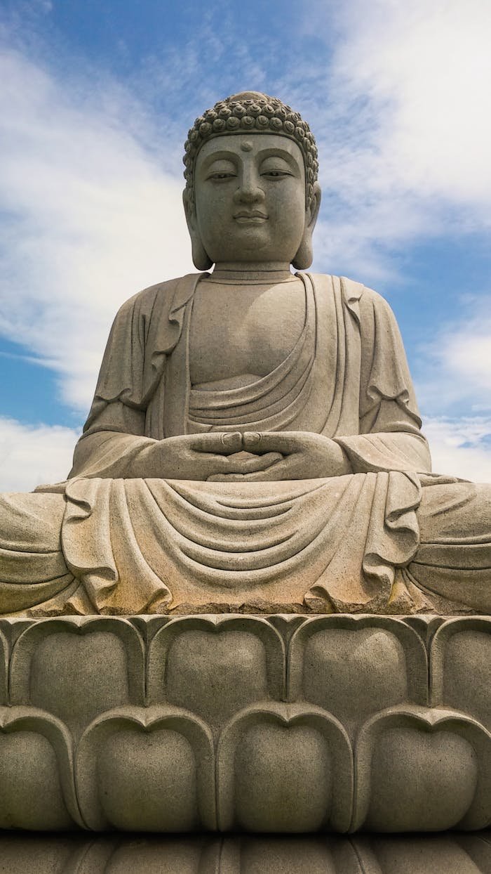 A peaceful Buddha statue beneath a clear blue sky, symbolizing tranquility and spirituality.