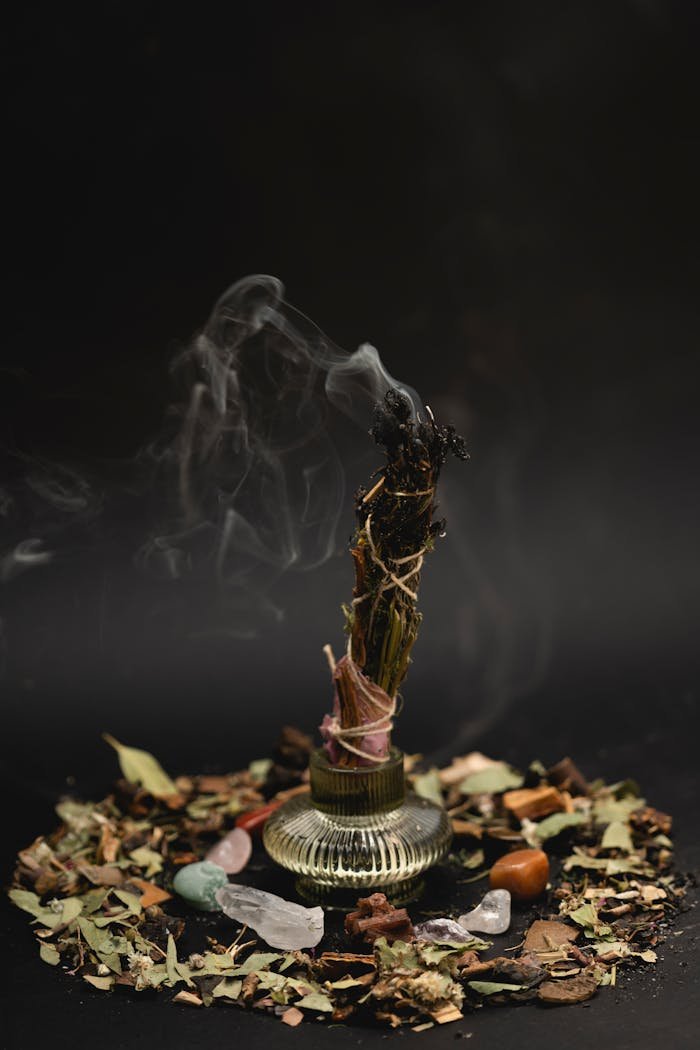 Herbal incense burning with aromatic smoke surrounded by healing crystals creating a spiritual ambiance.